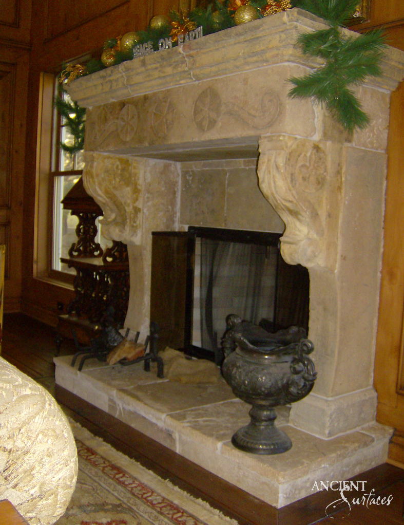Grand reclaimed French château limestone fireplace mantel from Ancient Surfaces with a carved rosette frieze and a two step raised stone hearth