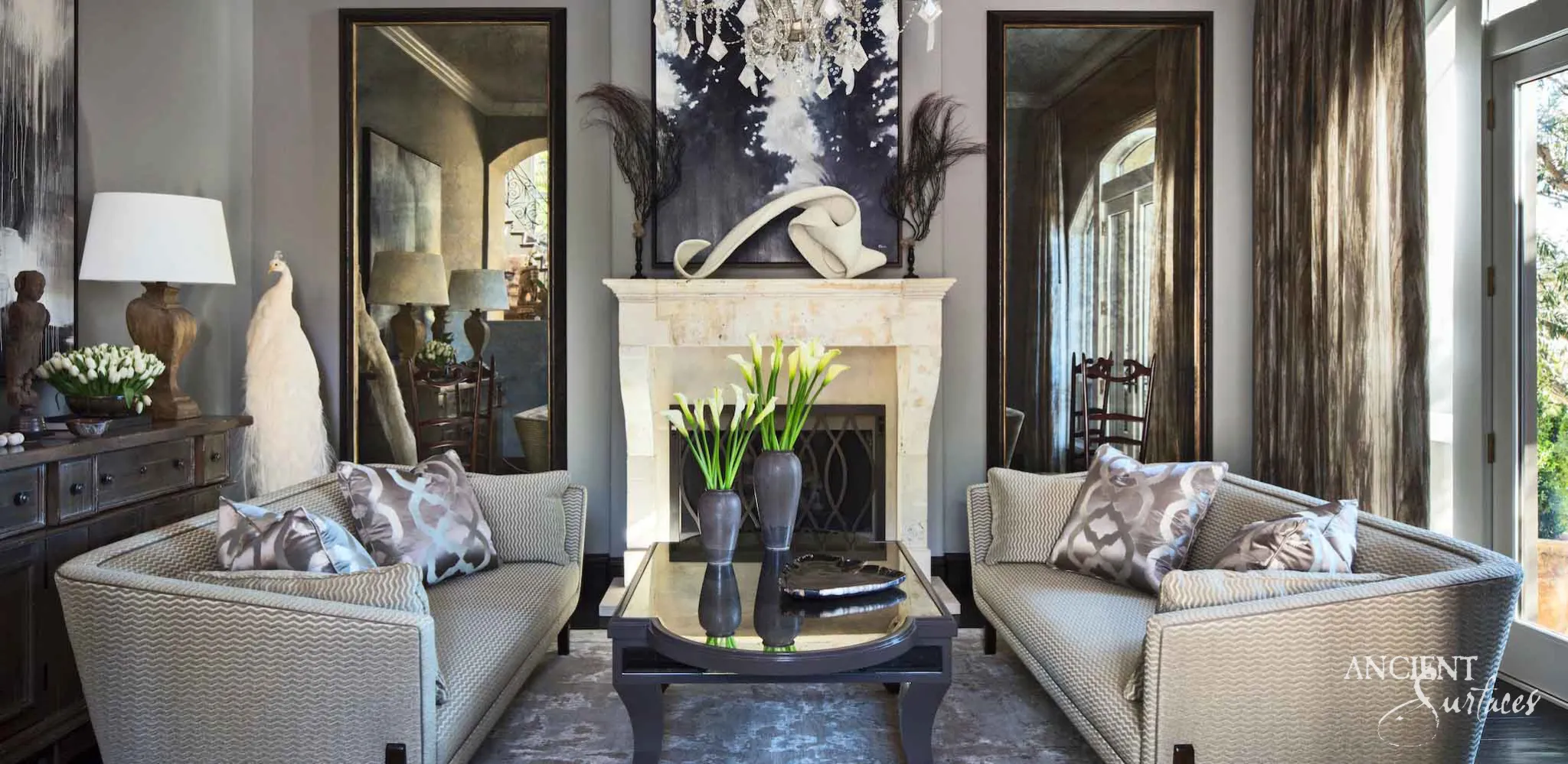 Reclaimed Louis XVI French limestone fireplace mantel from Ancient Surfaces with a carved keystone in a formal grey drawing room